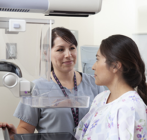 Proveedora de atención médica que coloca a una mujer en posición para una mamografía.